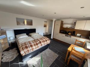 a bedroom with a large bed and a kitchen at M-Suites Petit - Near Frankfurt Airport in Hattersheim