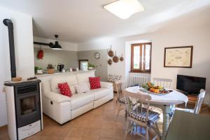 a living room with a white couch and a table at Al Veciarin in Lundo +18 photos