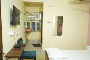 a room with a bed and a table and a sink at Hotel BLUE DIAMOND in Begusarai