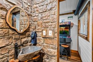 ein Steinbad mit einem Waschbecken und einem Spiegel in der Unterkunft High Bear Activity, Handicap Ramp, Hot Tub, Fire Table, Game Room, Family Cabin in Gatlinburg + 40 Fotos