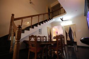 a dining room with a table and some stairs at Smiley Homestay in Varkala