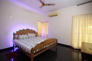 a bedroom with a bed in a room with purple lights at Smiley Homestay in Varkala