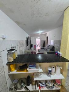 a kitchen with a counter top and a living room at Aluguel de quarto por diária in São Luís +7 photos