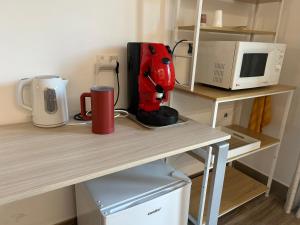 Una batidora roja sobre una mesa junto a un microondas en La dimora di Ipno, en Vallata