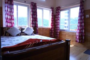 a bedroom with a bed with red curtains and windows at HAPPY NEST home stay valparai in Vālpārai