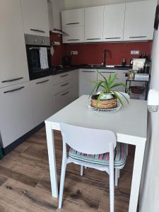 een keuken met een witte tafel met een plant erop bij Rose e fiori in Teulada +31 foto's