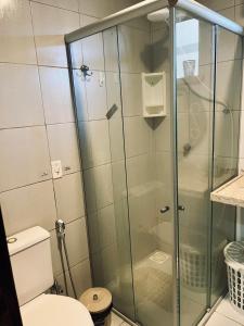 eine Glasdusche in einem Badezimmer mit Toilette in der Unterkunft Apto 2 quartos - Condomínio Frente Mar in Beberibe