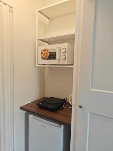 a small kitchen with a microwave in a room at Studio lumineux jardin privatif Paris & Disney in Noisy-le-Grand