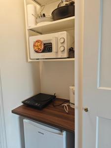 a microwave sitting on top of a kitchen counter at Studio lumineux jardin privatif Paris & Disney in Noisy-le-Grand +8 photos