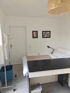 a bedroom with a bed with a desk and a lamp at Studio lumineux jardin privatif Paris & Disney in Noisy-le-Grand