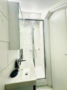 ノッティンガムにあるAvon Stone Apartmentsの洗面台とシャワー付きの白いバスルーム