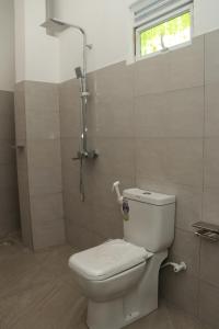 a bathroom with a toilet and a shower at Pabalu House in Ahangama