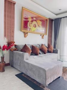 a living room with a couch and a painting on the wall at Jazzy Pool Villa Hatyai in Hat Yai +23 photos