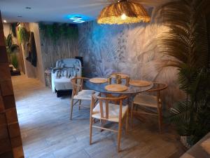 ein Esszimmer mit einem Tisch, Stühlen und einem Kinderbett in der Unterkunft Thermo'Spa - Gîte Spa Privatif in Calais