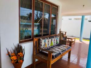 a living room with a bench and a window at Landa's Guest House in Praia do Tofo