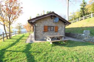 a small stone house in a field with a fence at Agriturismo Le Roncacce in Abetone
