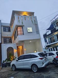 a white car parked in front of a house at savilla1 4 kamar dobel bed kolam renang dan biliard in Tlekung