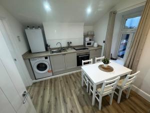 a kitchen with a table and a sink and a stove at Cinema room apartment 1 in Basildon