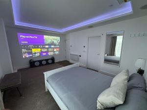 a bedroom with a large bed and a large screen at Cinema room apartment 1 in Basildon