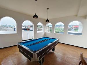 a pool table in a large room with windows at savilla1 4 kamar dobel bed kolam renang dan biliard in Tlekung
