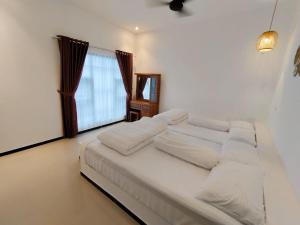 a large white bed in a room with a window at savilla1 4 kamar dobel bed kolam renang dan biliard in Tlekung +16 photos