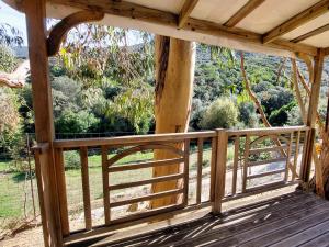 a wooden porch with a view of a forest at Mira Monti Location in Belvédère