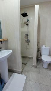 a bathroom with a white toilet and a sink at Appartement Coucher de Soleil Vue sur Mer pour les familles in Oualidia