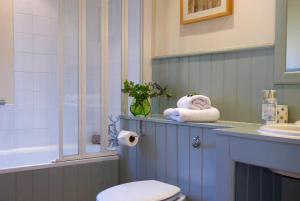 a bathroom with a sink and a toilet and a tub at Wilf's Barn, romantic cottage with free parking in Wedmore +31 photos