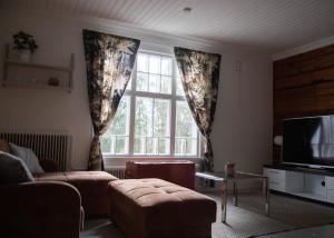 un soggiorno con un divano e una grande finestra di Willa Wanha Apteekki a Seinäjoki