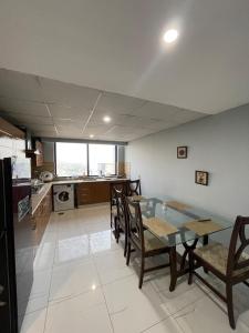 a kitchen and dining room with a glass table and chairs at The Triple-Bedroom Escape in Rawalpindi