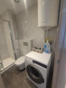 a small bathroom with a washing machine and a toilet at FONTANA FRONT of SEA APARTMENT in Budva +10 photos