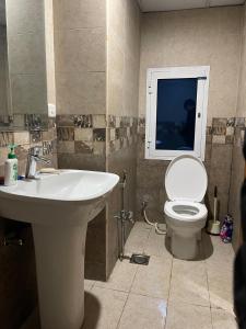 a bathroom with a sink and a toilet and a window at The Triple-Bedroom Escape in Rawalpindi