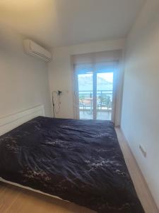 a bedroom with a large bed with a view of the ocean at FONTANA FRONT of SEA APARTMENT in Budva