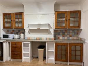EarlswoodにあるLondon Gatwick Guest Houseの木製のキャビネットとカウンタートップを備えたキッチン