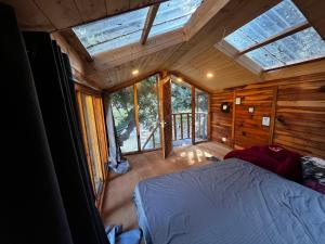 um quarto com uma cama em um quarto com janelas em Rumsu Tree House by SLC em Nagar