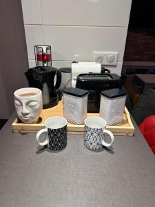 een groep koffiemokken op een houten dienblad bij Au Bord du Logelbach in Colmar