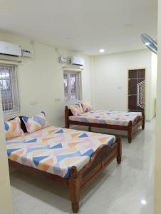 a room with two beds in a room at Guru Mahal in Pondūr