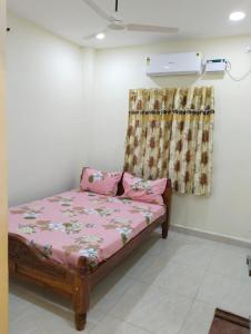 a bed in a room with a curtain at Guru Mahal in Pondūr
