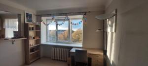 a room with a window with a desk and a table at Wolfs apartment in Rīga