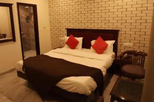 a bedroom with a large bed with red pillows at Hotel Premium in Chandīgarh