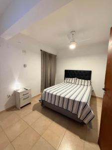 a bedroom with a large bed and a night stand at Alquiler Apartamento Resistencia Chaco in Resistencia