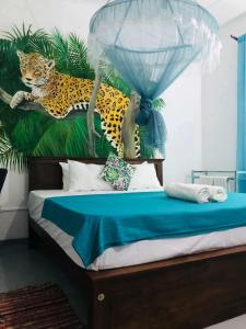 a bedroom with a bed with a painting of a leopard at Casa Del Ceylon in Hikkaduwa +48 photos