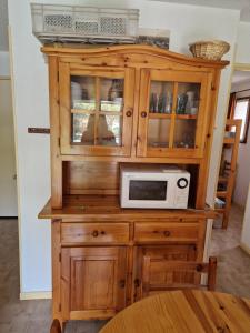 a wooden cabinet with a microwave on top of it at T2 familial climatisé mer à pied parking privé in Saint Cyprien Plage