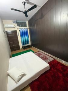 バラナシにあるPankali niwasの白いベッドと天井ファンのある寝室