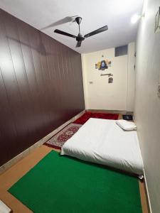 バラナシにあるPankali niwasのベッドと天井扇風機のある部屋 +13枚の写真