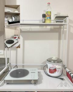 a kitchen with a shelf and a slow cooker at Casa Lena - Bulacan Staycation in Marilao