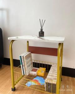 a yellow table with books on a shelf at Casa Lena - Bulacan Staycation in Marilao