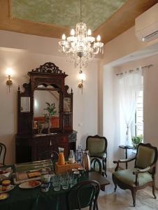 a dining room with a table and a chandelier at Archontiko Hotel in Kalymnos +66 photos