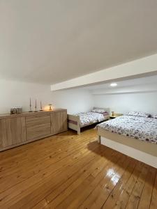 Dos camas en una habitación con suelo de madera. en La Hitana, en Lazarevac 8 fotos más