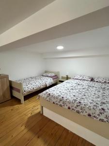 Dos camas en una habitación con suelo de madera. en La Hitana, en Lazarevac